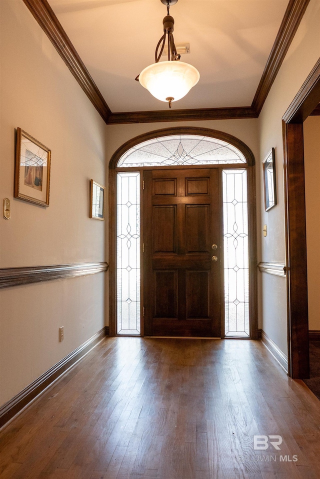 entrance foyer featuring crown molding, dark wood-type flooring, and a healthy amount of sunlight