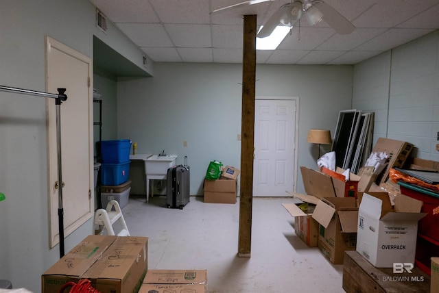 basement with a drop ceiling and ceiling fan