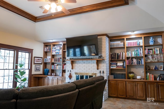 living room featuring crown molding, a brick fireplace, built in features, and ceiling fan