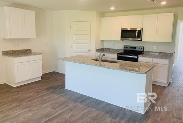 kitchen featuring white cabinets, appliances with stainless steel finishes, a kitchen island with sink, and dark hardwood / wood-style flooring