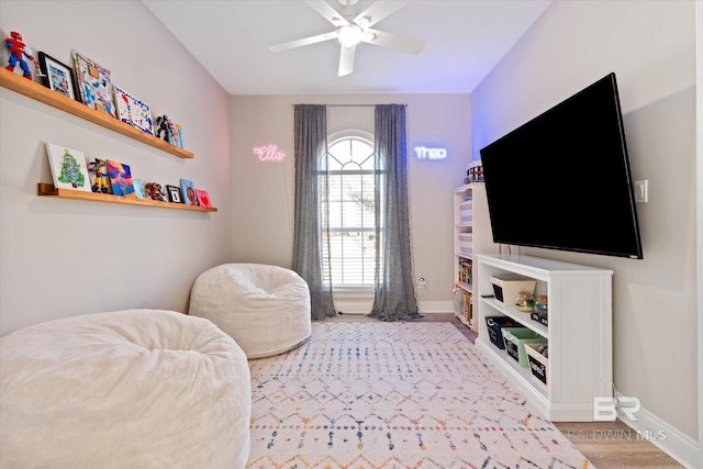 sitting room with hardwood / wood-style floors and ceiling fan