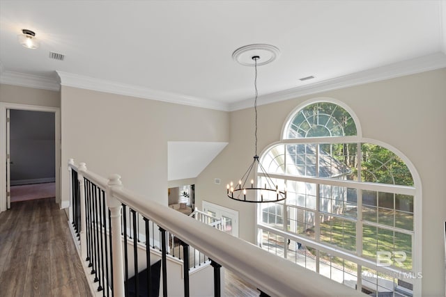 corridor with hardwood / wood-style floors, a notable chandelier, and crown molding