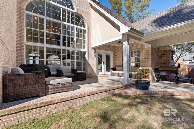 property entrance with an outdoor living space, ceiling fan, a patio area, and french doors