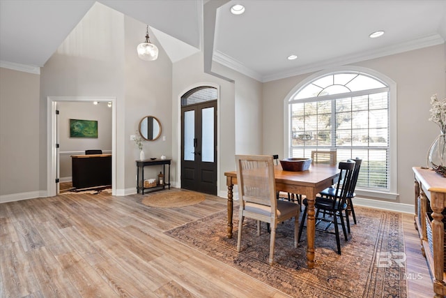 dining area featuring wood-type flooring, vaulted ceiling, french doors, and ornamental molding