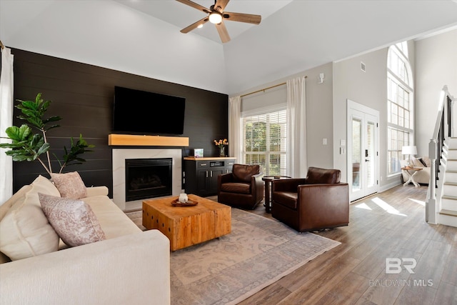 living room featuring wood-type flooring, high vaulted ceiling, and ceiling fan