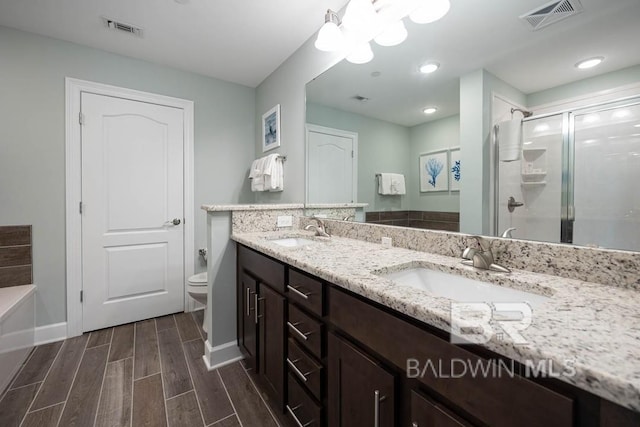 bathroom with visible vents, a sink, and a stall shower