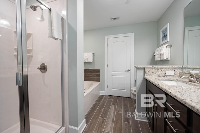 bathroom with visible vents, wood finish floors, and a shower stall