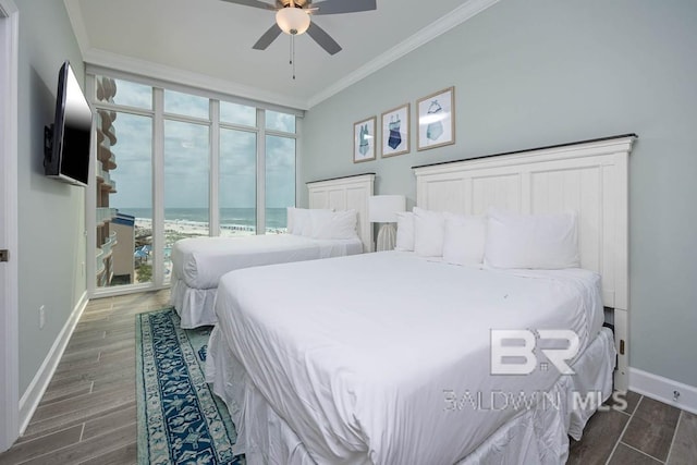 bedroom featuring a wall of windows, a ceiling fan, crown molding, wood finished floors, and baseboards