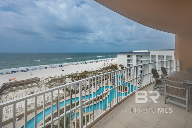 balcony featuring a beach view and a water view