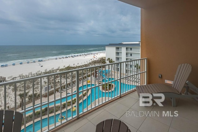 balcony with a water view and a view of the beach