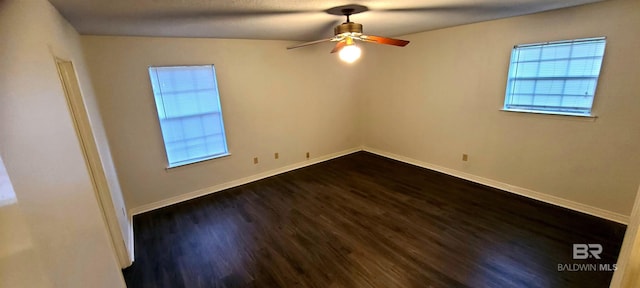 spare room with dark hardwood / wood-style floors and ceiling fan