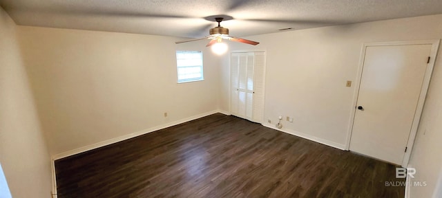 unfurnished room featuring a textured ceiling, dark hardwood / wood-style floors, and ceiling fan