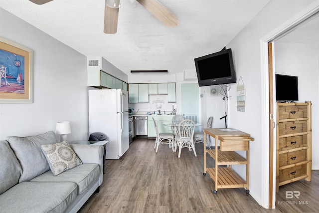 living room with ceiling fan, dark wood-type flooring, a textured ceiling, and visible vents