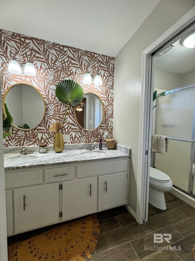 bathroom with vanity, toilet, and a shower with shower door