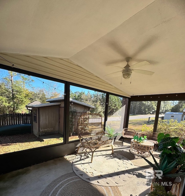 unfurnished sunroom featuring a wealth of natural light, ceiling fan, and lofted ceiling