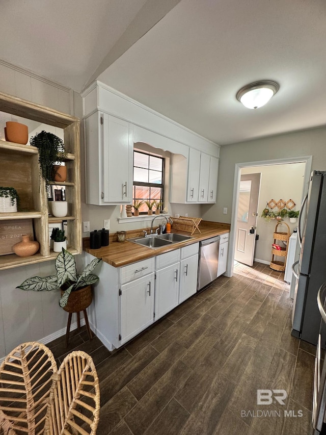 kitchen with white cabinets, stainless steel appliances, butcher block countertops, and sink