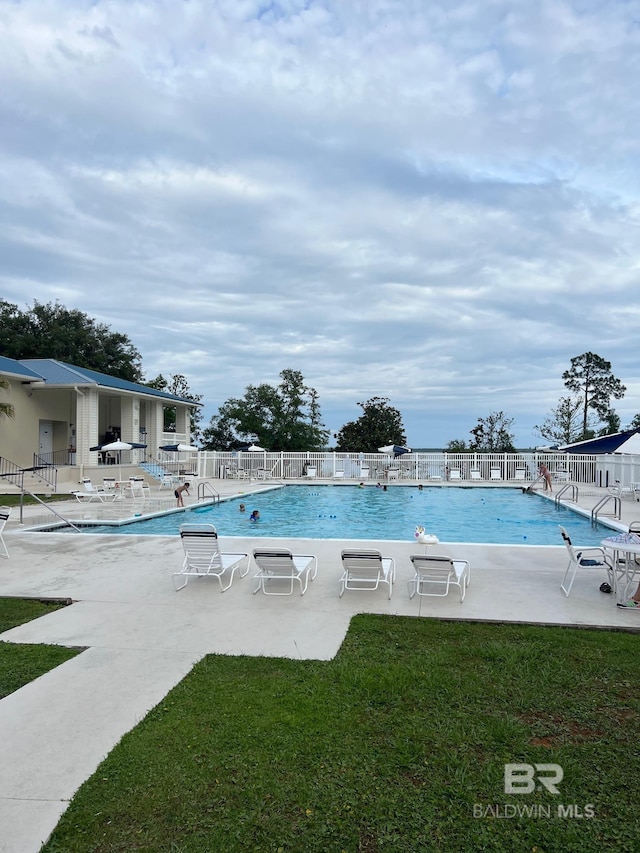 view of pool with a lawn and a patio area