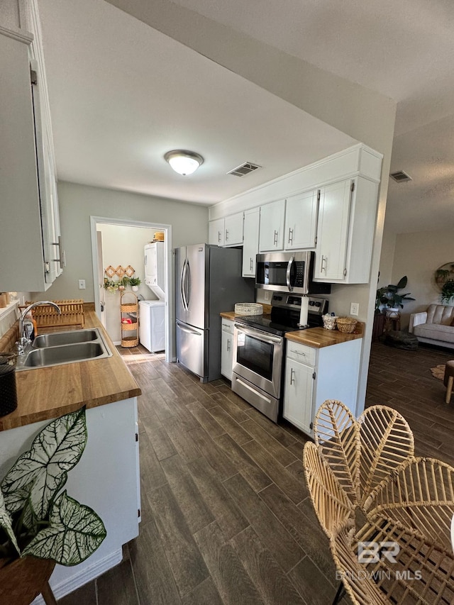 kitchen featuring appliances with stainless steel finishes, dark hardwood / wood-style floors, white cabinetry, and sink