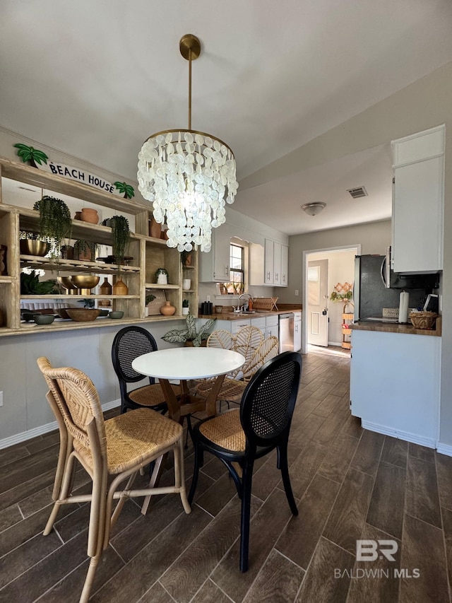 dining area with sink and a chandelier