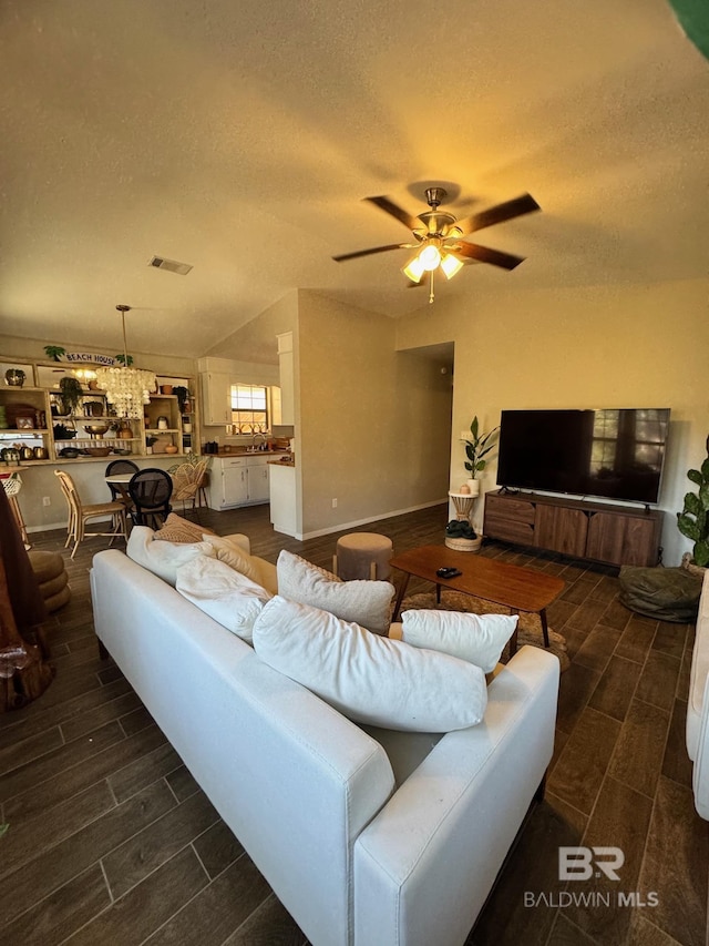 living room with a textured ceiling and ceiling fan