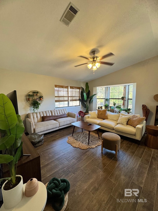 living room with a textured ceiling, dark wood-type flooring, ceiling fan, and lofted ceiling