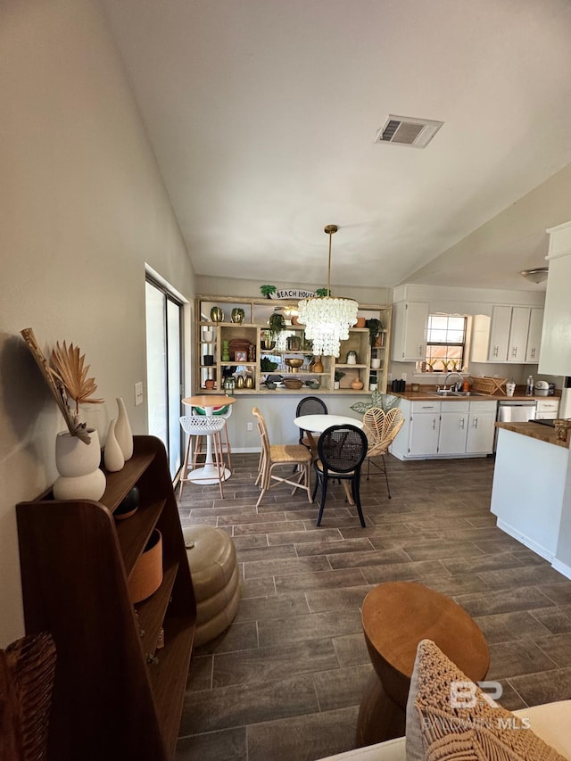 dining area with lofted ceiling and an inviting chandelier