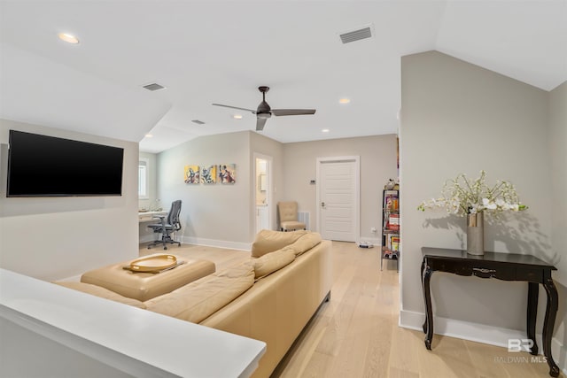 living room with vaulted ceiling, ceiling fan, and light wood-type flooring