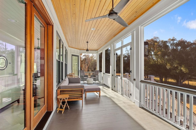 sunroom / solarium featuring ceiling fan, wood ceiling, and a healthy amount of sunlight