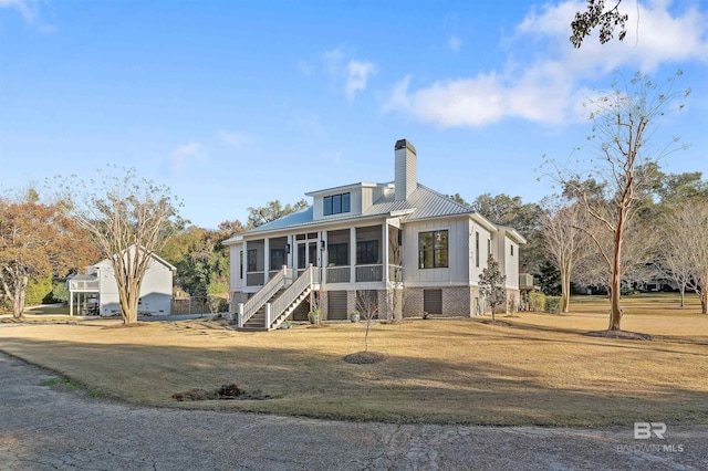 view of front of home with a front lawn and a sunroom