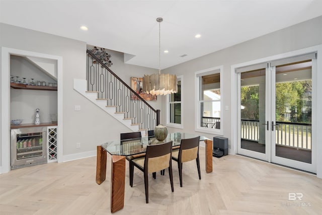 dining area featuring french doors, light parquet flooring, and a chandelier