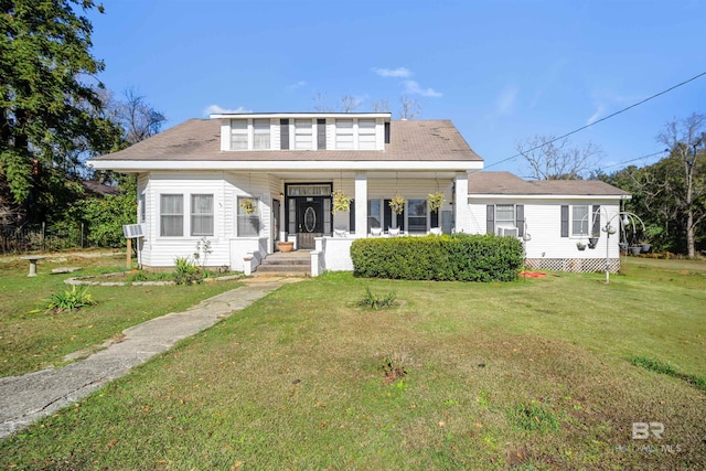 bungalow featuring cooling unit, covered porch, and a front yard