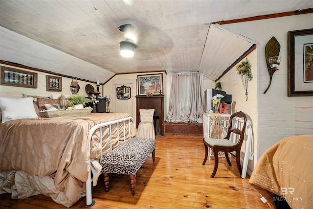 bedroom with hardwood / wood-style flooring, vaulted ceiling, wood walls, and wood ceiling