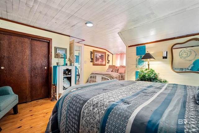 bedroom with light hardwood / wood-style flooring, a closet, wooden ceiling, and wood walls