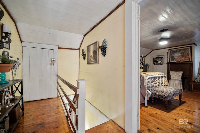 hall featuring hardwood / wood-style floors, wood ceiling, and vaulted ceiling