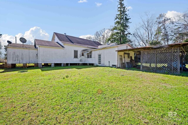 rear view of property featuring a lawn