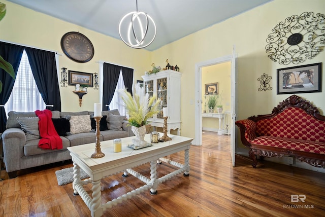 living room featuring wood-type flooring and an inviting chandelier