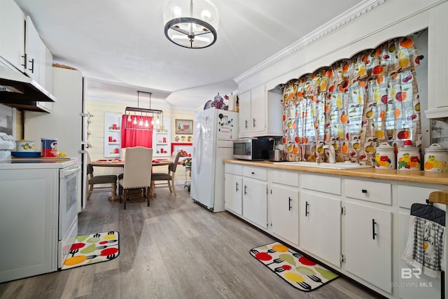 kitchen featuring pendant lighting, white appliances, and white cabinetry