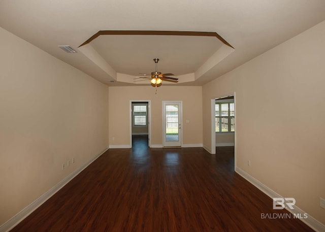 unfurnished room with ceiling fan, a tray ceiling, and hardwood / wood-style floors