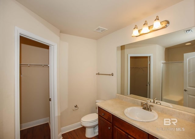 bathroom featuring a shower with door, wood-type flooring, toilet, and vanity