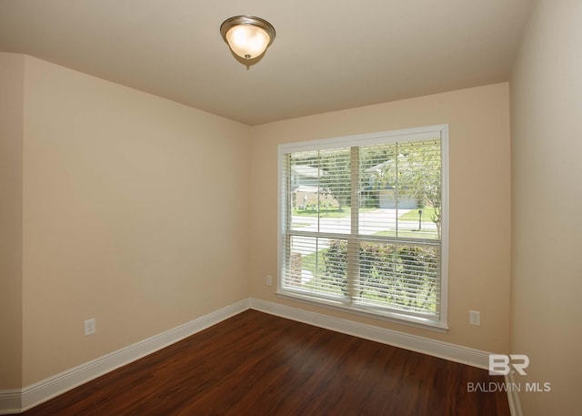 spare room featuring a wealth of natural light and hardwood / wood-style floors