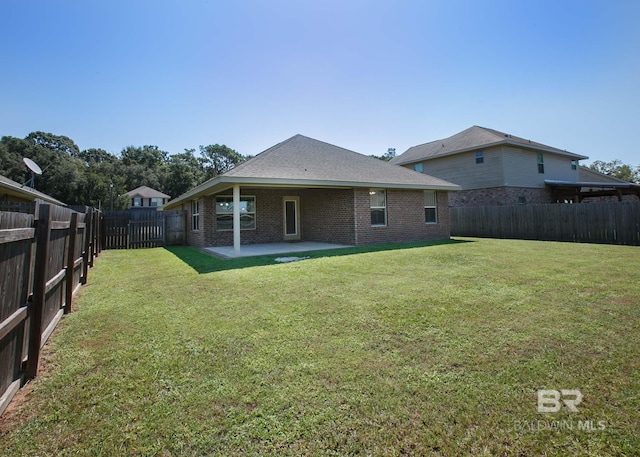 rear view of property with a lawn and a patio area