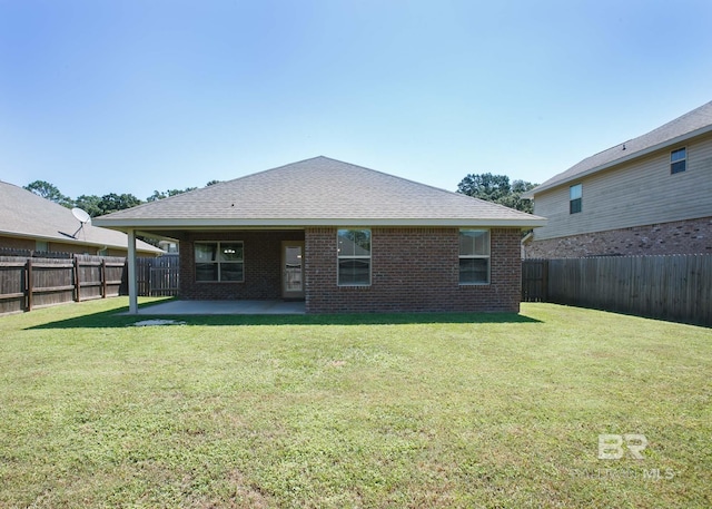 back of house with a yard and a patio