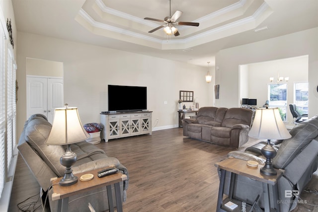 living area with crown molding, a ceiling fan, a tray ceiling, and wood finished floors