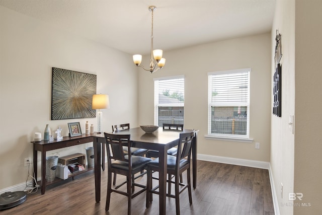 dining area with an inviting chandelier, dark wood-style flooring, and baseboards