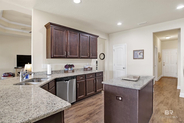 kitchen with dark brown cabinets, light stone counters, a sink, dishwasher, and light wood-type flooring
