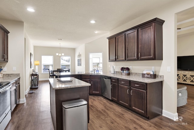 kitchen featuring dark brown cabinetry, stainless steel appliances, dark wood-style floors, and a wealth of natural light