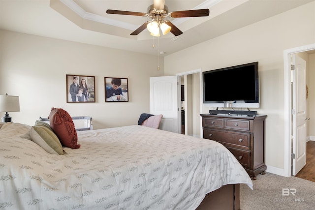 bedroom with carpet floors, a ceiling fan, baseboards, and a raised ceiling