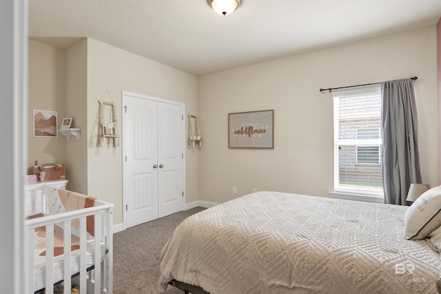 carpeted bedroom featuring baseboards and a closet