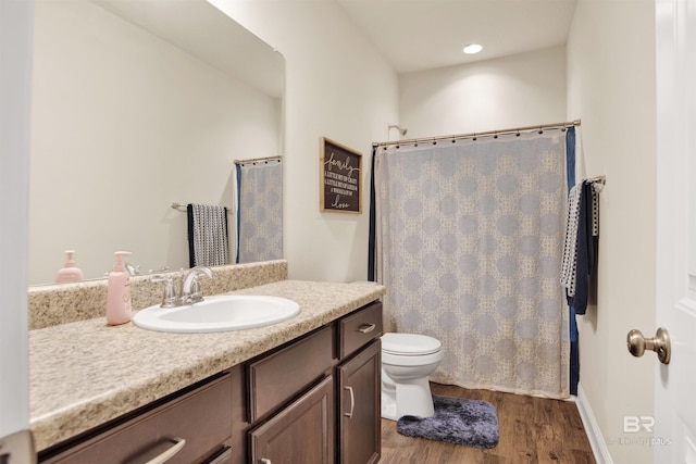 bathroom with vanity, a shower with curtain, toilet, and wood finished floors