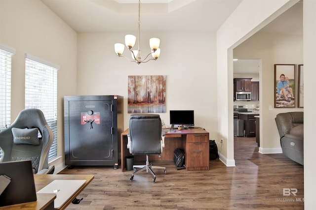 office area with baseboards, wood finished floors, and a chandelier